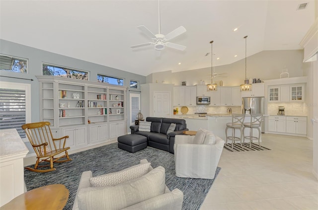 tiled living room featuring ceiling fan and high vaulted ceiling