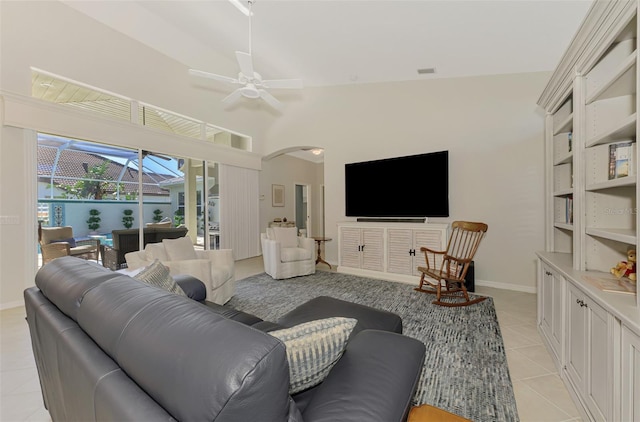 living room featuring ceiling fan, light tile patterned floors, and vaulted ceiling