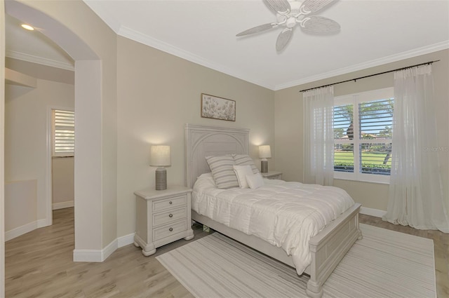 bedroom with ceiling fan, light hardwood / wood-style floors, and ornamental molding