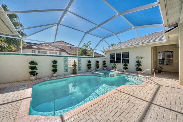 view of pool featuring glass enclosure, an in ground hot tub, and a patio