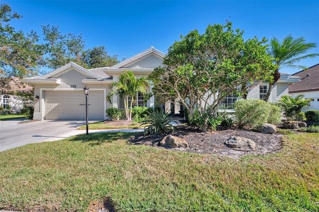 view of property hidden behind natural elements featuring a garage, driveway, a front yard, and stucco siding