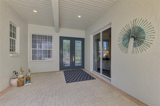 view of exterior entry featuring stucco siding and french doors