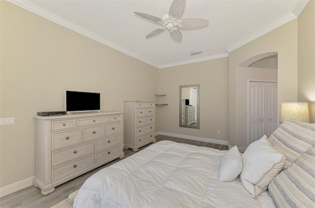 bedroom with light wood finished floors, visible vents, baseboards, a ceiling fan, and crown molding