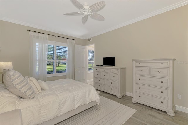 bedroom with ornamental molding, baseboards, light wood finished floors, and a ceiling fan