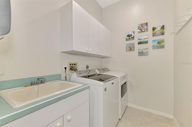 clothes washing area with light tile patterned floors, cabinet space, a sink, independent washer and dryer, and baseboards