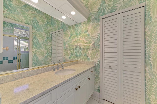 full bathroom with wallpapered walls, a closet, and vanity