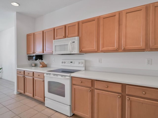 kitchen featuring light tile patterned flooring and white appliances