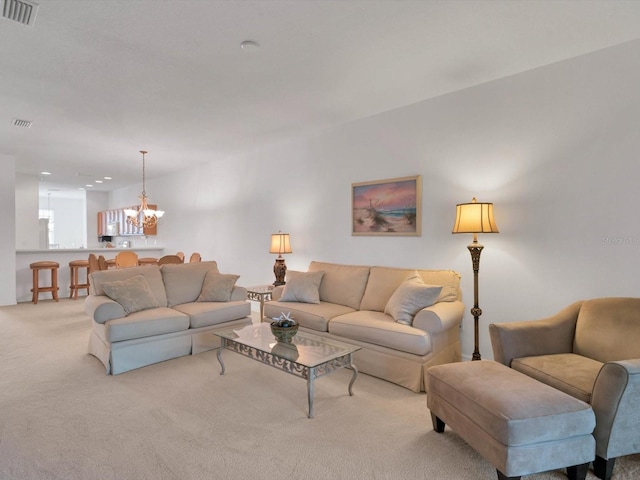 living room with light colored carpet and an inviting chandelier