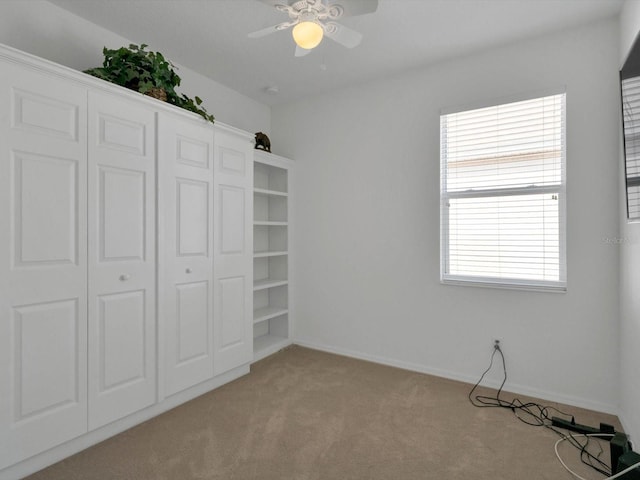 unfurnished bedroom featuring light carpet and ceiling fan