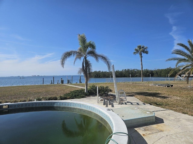 view of swimming pool with a lawn and a water view