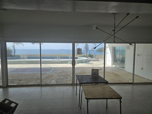 unfurnished sunroom with plenty of natural light and a water view