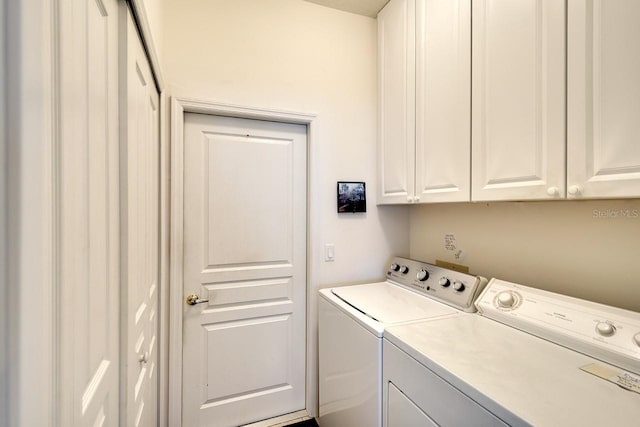 clothes washing area featuring cabinets and washing machine and dryer