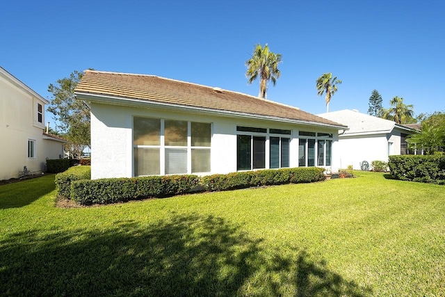 rear view of property featuring a lawn