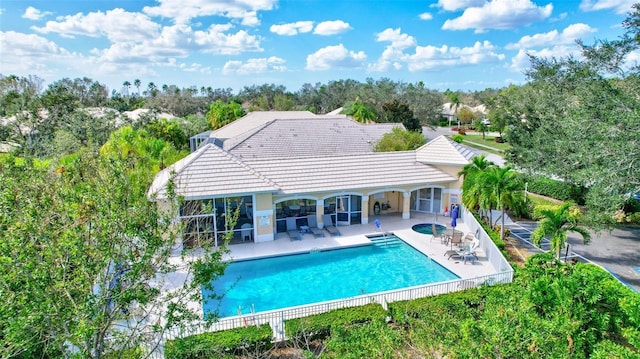 view of swimming pool featuring a patio and a hot tub