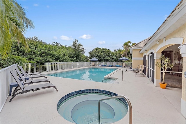 view of pool featuring a community hot tub and a patio area