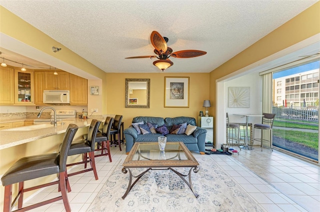 tiled living room featuring a textured ceiling and ceiling fan