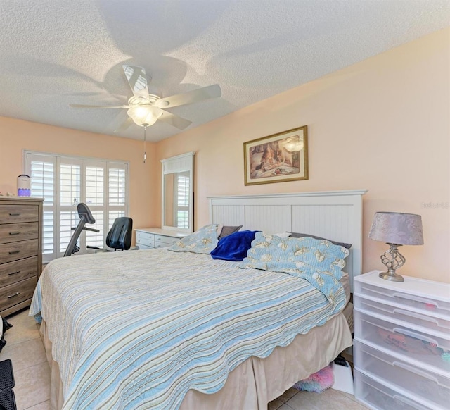 tiled bedroom featuring a textured ceiling and ceiling fan