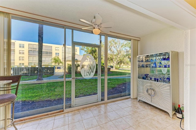 entryway with tile patterned floors, ceiling fan, and a textured ceiling