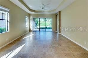 empty room with a raised ceiling and ceiling fan