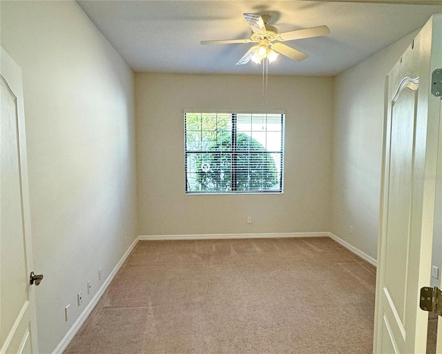 spare room featuring light carpet and ceiling fan