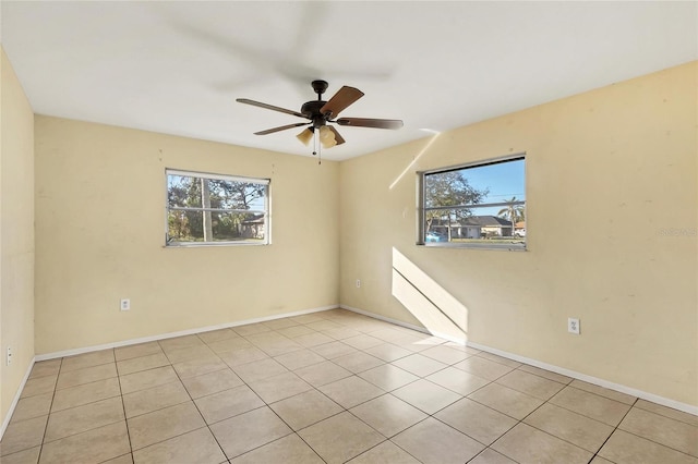 tiled spare room with ceiling fan