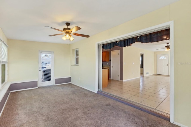 carpeted spare room featuring ceiling fan