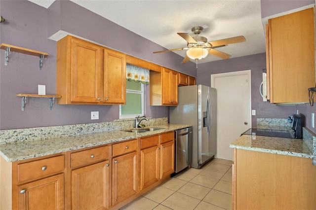 kitchen featuring light stone countertops, stainless steel appliances, ceiling fan, sink, and light tile patterned flooring