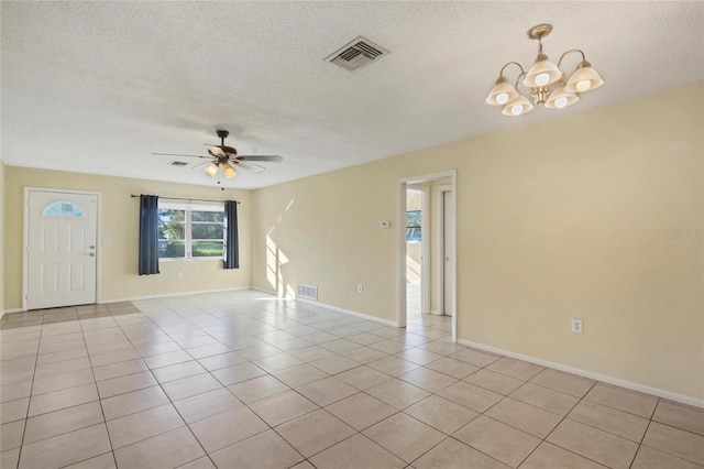 unfurnished room with light tile patterned floors, ceiling fan with notable chandelier, and a textured ceiling