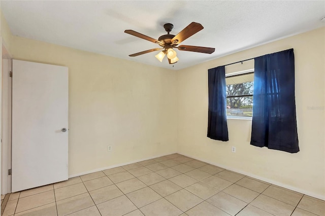 tiled spare room with ceiling fan