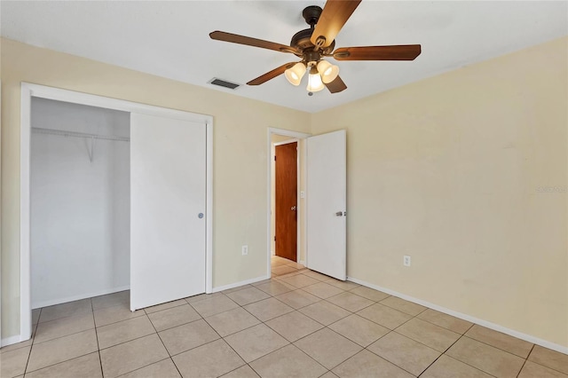 unfurnished bedroom featuring ceiling fan, light tile patterned floors, and a closet