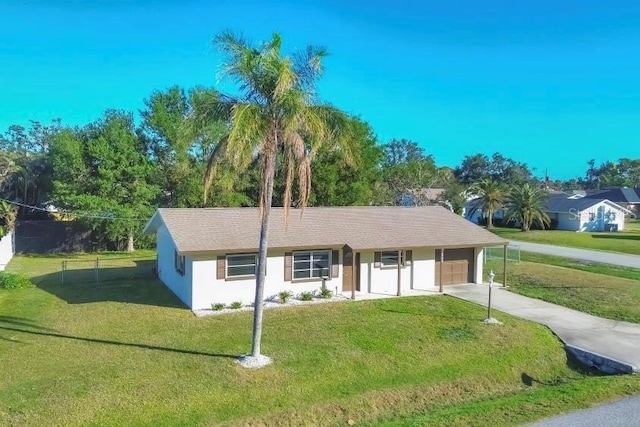 ranch-style house with a front yard, driveway, an attached garage, and stucco siding