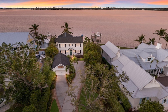 aerial view at dusk featuring a water view