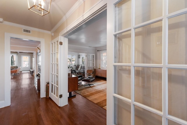 entrance foyer with french doors, dark wood finished floors, crown molding, visible vents, and a chandelier