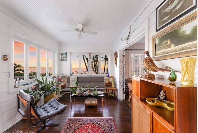 sitting room with dark wood-style floors, plenty of natural light, and ceiling fan