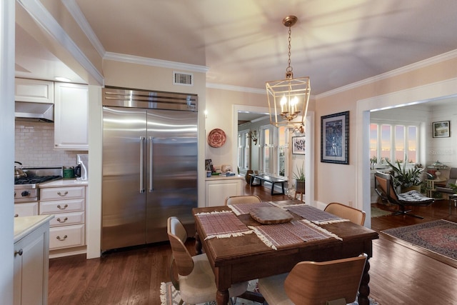 dining room with dark hardwood / wood-style flooring, crown molding, and a notable chandelier