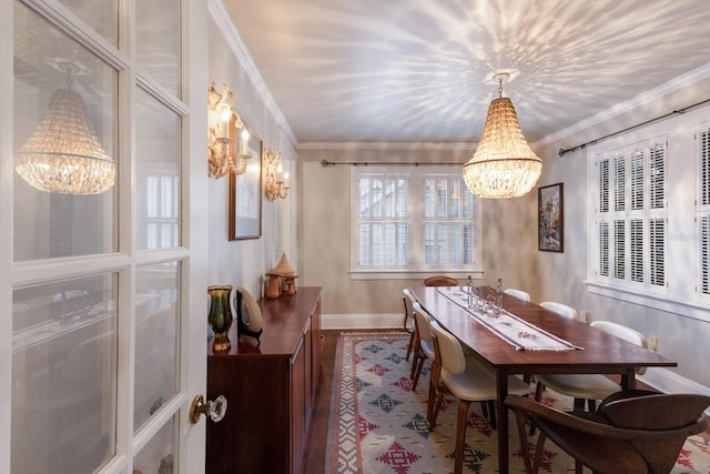 dining room with ornamental molding, wood finished floors, baseboards, and an inviting chandelier