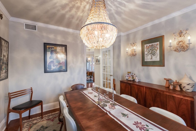 dining room with wood-type flooring, an inviting chandelier, and ornamental molding