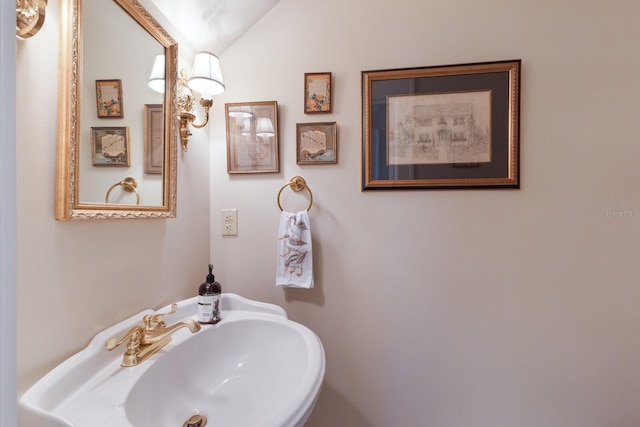 bathroom featuring lofted ceiling and sink