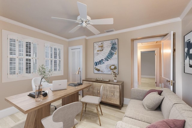 office area with light wood finished floors, visible vents, baseboards, a ceiling fan, and crown molding