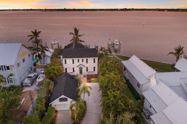 aerial view at dusk featuring a water view