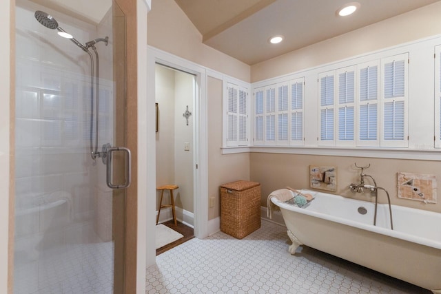 bathroom featuring baseboards, a soaking tub, a shower stall, and recessed lighting