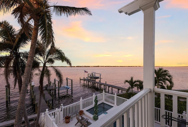 view of dock with a balcony and a water view