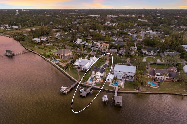 aerial view at dusk featuring a water view