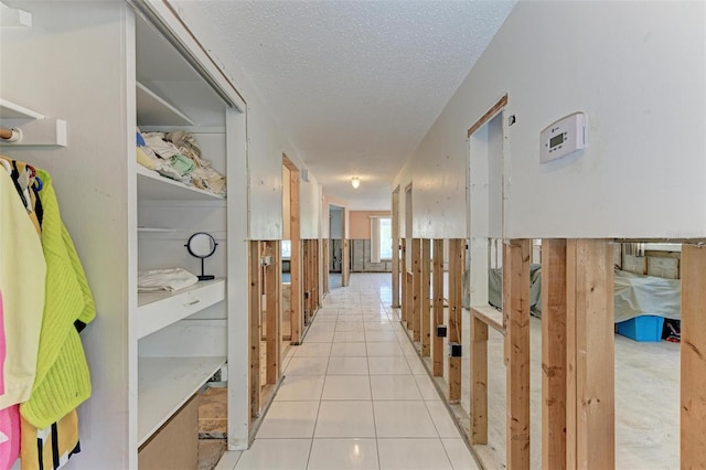 corridor with light tile patterned floors and a textured ceiling