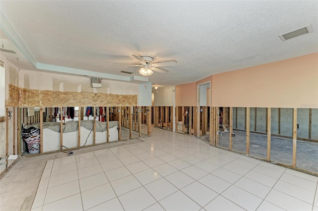 unfurnished room with ceiling fan and a textured ceiling