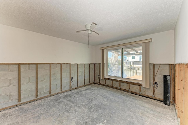 carpeted spare room featuring ceiling fan and a textured ceiling