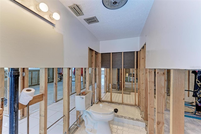 bathroom with a textured ceiling and toilet