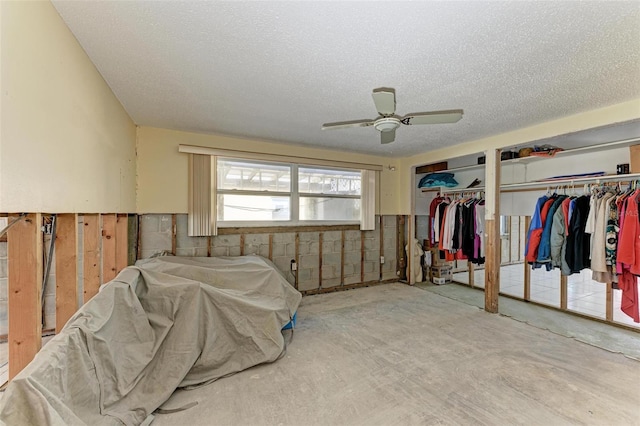 bedroom featuring ceiling fan, concrete flooring, a textured ceiling, and multiple closets