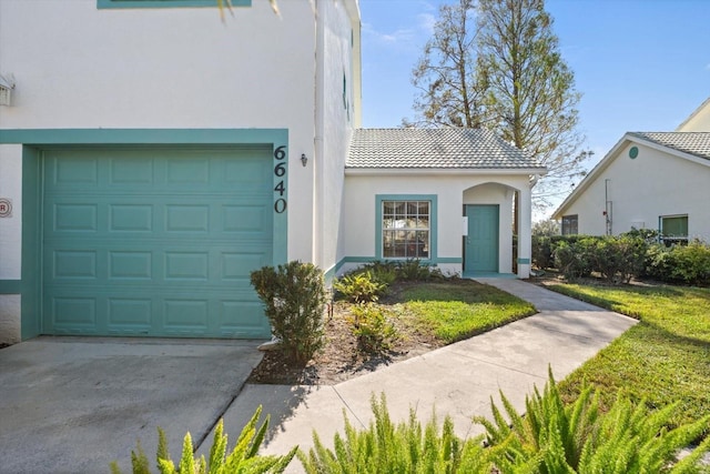 view of front of property featuring a garage and a front lawn