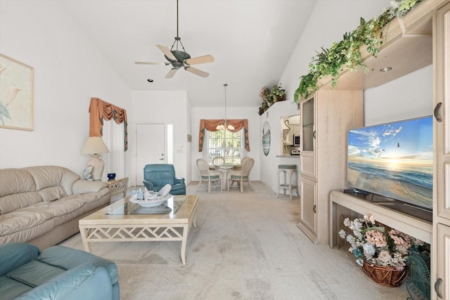 carpeted living room with ceiling fan and high vaulted ceiling